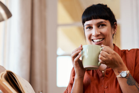 Coffee is what keeps the magic alive. an attractive young woman drinking coffee while relaxing at home.の写真素材