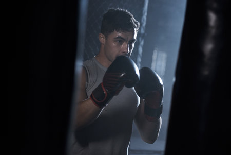 The right form reaps the full benefits. a young man practicing his boxing routine at a gym.の写真素材