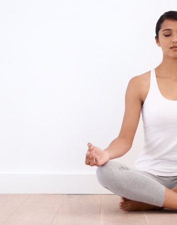 A moment of Tranquility. A beautiful young woman in the lotus position.の写真素材
