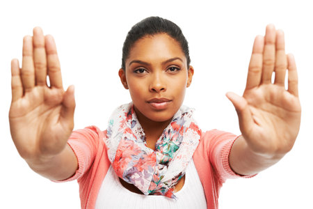 Being firm and saying no. Pretty yougn woman gesturing STOP against a white background.の写真素材