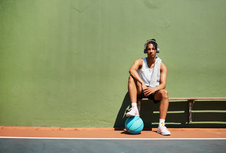 Start unknown, finish unforgettable. Portrait of a sporty young man taking a break after a game of basketball.の写真素材