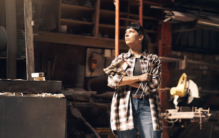 The days of apprenticeship are long behind her. a confident young woman looking thoughtful while working at a foundry.の写真素材