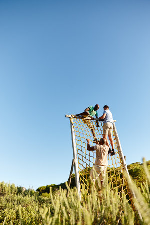 No obstacle too big...a group of men going through an obstacle course at military bootcamp.の写真素材