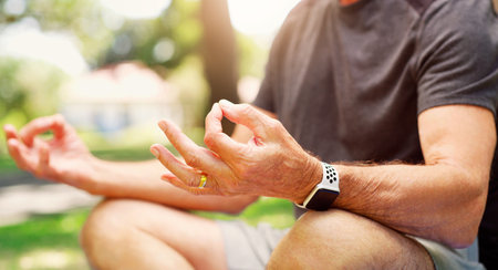 Old man outdoor, yoga and meditation with lotus pose, fitness in park with zen and spiritual healing. Male person hand, exercise in nature and retirement, health with wellness and mindfulnessの写真素材