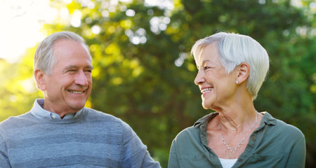 Senior couple, happy and love outdoor at a park with a smile, care and support for health and...