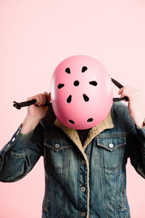 Let me get this on quick. an unrecognisable man standing alone in the studio and putting a helmet on.の写真素材