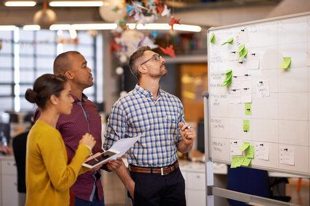 Whiteboard, thinking and business people with optimisation strategy in a office. Startup, company training and creative writing group with communication and vision with ideas and writer sticky notesの写真素材