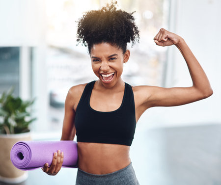 Black woman, flex and muscle for fitness or portrait of motivated athlete or yoga mat and happy for exercise indoors. Workout, training and girl runner energy or goal for muscle in gym for sportsの写真素材
