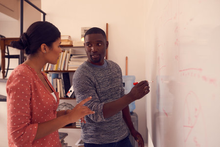 Kicking off their project with a brainstorming session. a young businessman and businesswoman having...