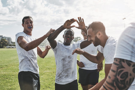 See you all next time. a group of cheerful young rugby players celebrating their win after a match outside during the day.の写真素材
