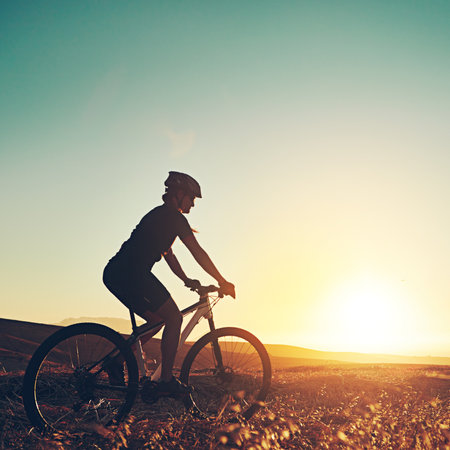 Fierce, fit and female. an adventurous mountain biker out for a ride in the countryside.の写真素材