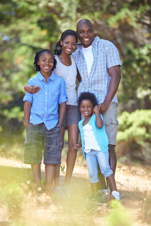 Portrait of an active family. Portrait of an african american family enjoying a day out in the forest.の写真素材
