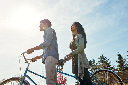 Out to see the beauty that surrounds us. a young couple out for a ride on a tandem bicycle.の写真素材