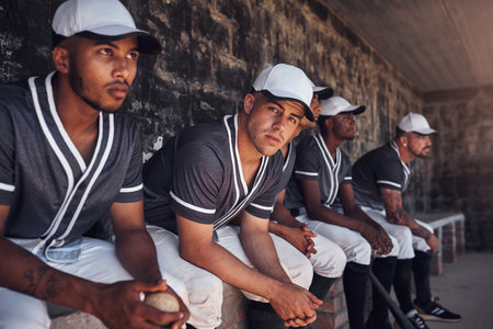 As exciting to watch as it is to play. a group of young men watching a game of baseball from the dugout.の写真素材