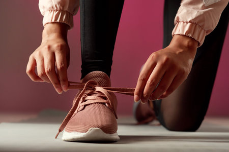 You better get ready and get started. Studio shot of an unrecognisable woman tying her shoelaces...