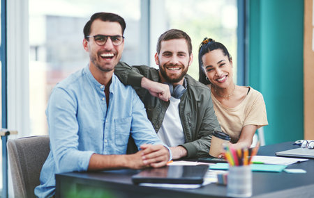 Outstanding work comes from the effort of a team. Portrait of a group of young designers working together in an office.の写真素材