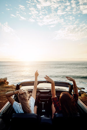 Where will this summer take you. a two happy young women enjoying a summers road trip together.の写真素材