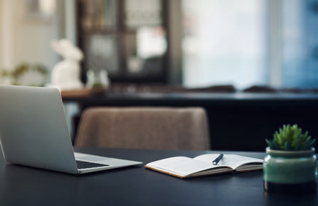 Hard work is exactly what it takes to succeed. Still life shot of a laptop and notebook on a table in an office.の写真素材