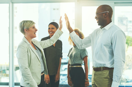 High five, winner and motivation with business people in office for success, happy and agreement....