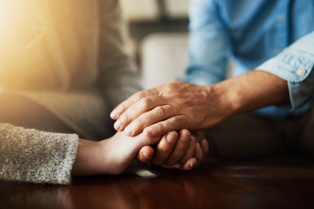 Holding hands, senior couple and life insurance support with kindness in a house. Home, love and elderly people with empathy, hope and trust with solidarity for grief care and marriage togetherの写真素材