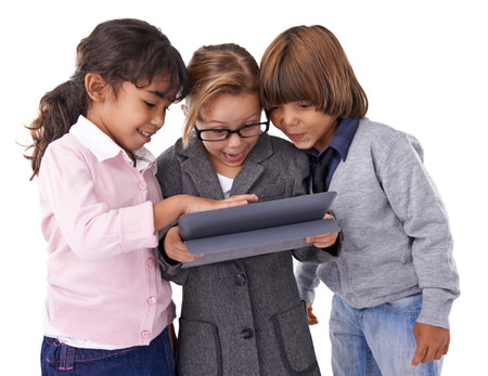 Exploring new worlds. Studio shot of three kids standing and working on a tablet.の写真素材