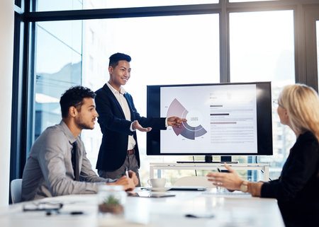 Presentation, meeting and training with a business man talking to his team in the office boardroom. Finance, workshop and education with an asian coach teaching staff using a graph display at workの写真素材