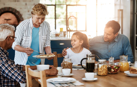 Theres a lot more if anyone wants. a multi generational family enjoying breakfast together at home.の写真素材