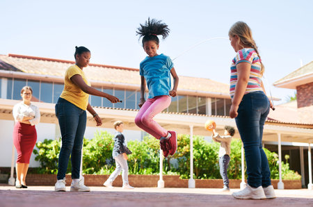 Its never too late to learn new motor skills. Full length shot of a diverse group of children playing outside during recess at school.の写真素材