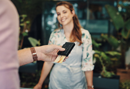 Punching in my pin. an unrecognizable man using his credit card to purchase from a florist.