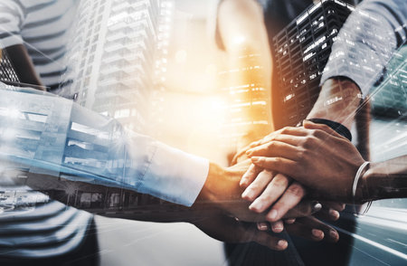 Well stand by each other no matter what. Closeup shot of a group of businesspeople joining their hands together in a huddle.の写真素材