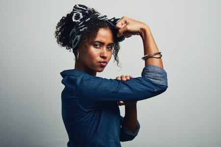 Time to woman up. Studio shot of an attractive young woman posing against a grey background.の写真素材