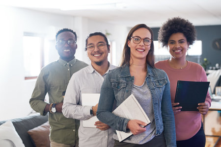 Inclusivity keeps us at the forefront of business. Portrait of a group of confident young businesspeople working in a modern office.の写真素材