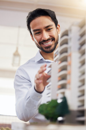 Architect, happy man and check architecture model, construction and building with smile on face and building project. Businessman in office, design and engineer, property development and constructionの写真素材