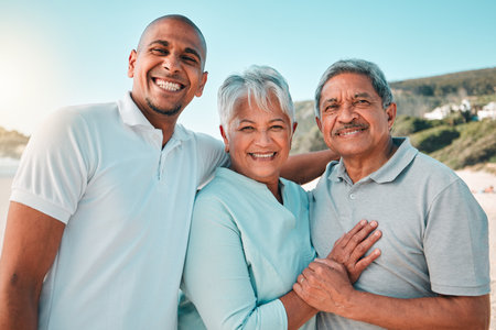 Happy, hug and a portrait of a family at the beach for bonding and quality time on the weekend. Smile, relax and a senior mother and father hugging with an adult man during a holiday at the seaの写真素材