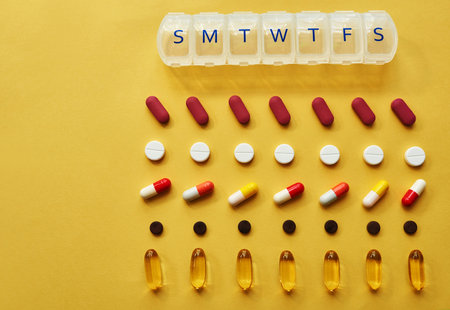 By the end of the week youll be feeling better. Studio shot of tablets and a medicine organizer against a yellow background.の写真素材