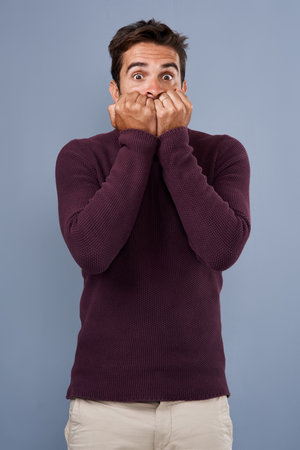 I think we should get outta here. Studio shot of a handsome young man looking scared against a gray background.の写真素材