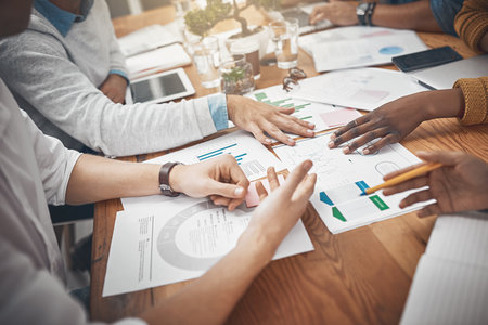 Gathering the team to make some crucial decisions. a group of businesspeople discussing statistics.の写真素材