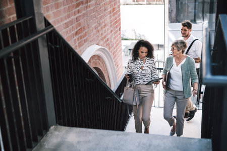 Teamwork fuels forward motion. two businesswomen having a discussion while walking up the stairs in...