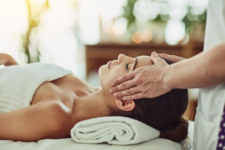 Spend a little time on yourself. an attractive young woman getting massaged at a beauty spa.の写真素材