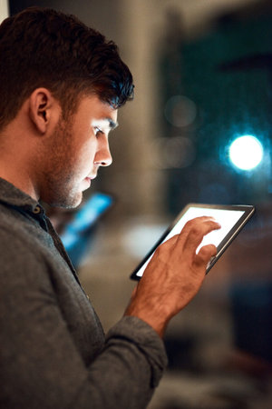 I know exactly how to make a name for myself. a businessman using a digital tablet while standing...