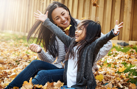 Pile on the leaves, piles of fun. an adorable little girl enjoying an autumn day outdoors.