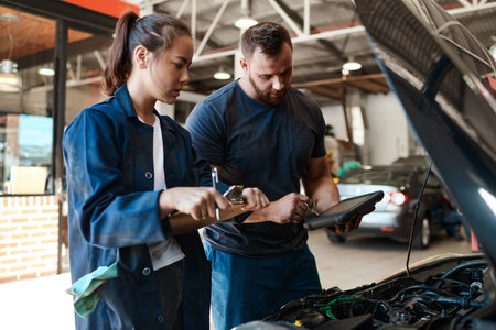 You should only trust the best when it comes to your car. a mechanic using a digital tablet while talking to his colleague.の写真素材