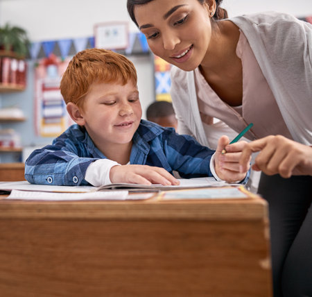 She adores helping her students. elementary school children in class.の写真素材