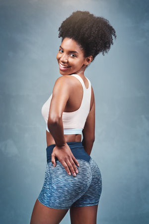 I worked hard to look this good. Studio shot of an attractive young woman in exercise clothing against a gray background.の写真素材