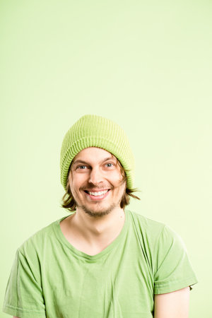 I have to tell you something interesting. a handsome young man standing alone in the studio and posing while wearing a beanie.の写真素材