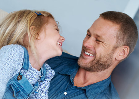 Dads always tell the best jokes. an adorable little girl laughing with her father.