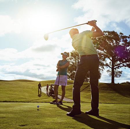He just keeps getting better anf better. a couple playing golf together on a fairway.の写真素材