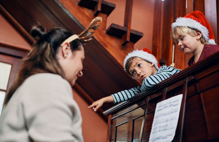 Sure, I take requests from the audience. a young woman playing the piano for her sons at Christmas.の写真素材