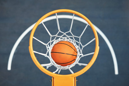 Eat, sleep, dunk, repeat. Closeup shot of a basketball landing into a net on a sports court.
