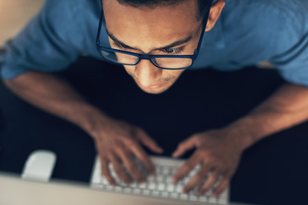 Working for a better me. a young using a computer in a modern office.の写真素材